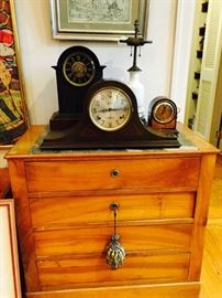 An assortment of antique/vintage clocks, vintage lamp and antique bachelor's chest