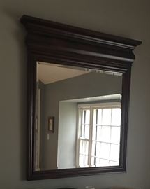 Library mirror.  Beveled mirror crowned with grand moldings and framed in solid wood with mahogany, cherry and birch inlays and veneers.  Dimensions:  42 x 46 x4.