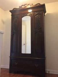 Beautiful antique armoire with hand carved detail and mirror on door. Large drawer.