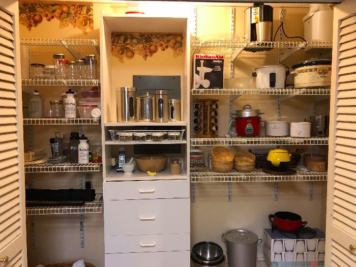 Super enviously organized pantry. We got Crockpots, coffee makers, a collection of jars, water bottles -- is that a FONDUE SET?? IT IS!