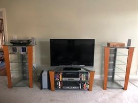 Entertainment ensemble — two wood and glass three-tiered bookcases and glass and wood TV stand