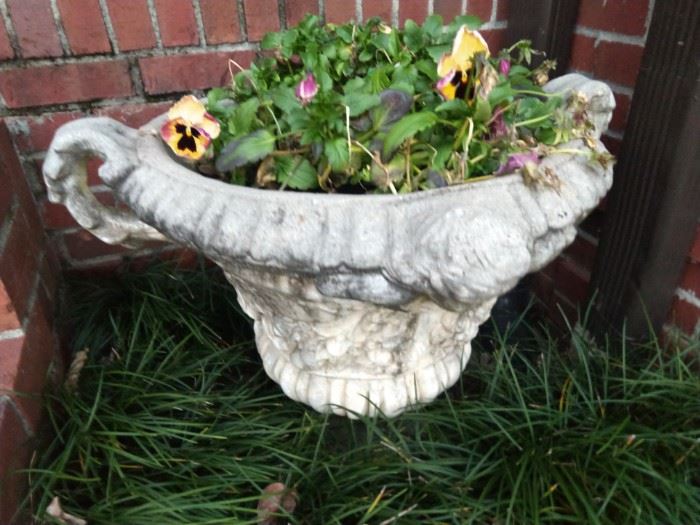 There is a pair of these spring-like concrete pots, planted with butch pansies.