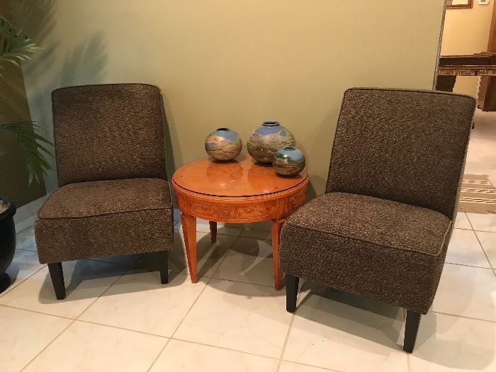 Two slipper chairs and round accent table with carved, glass covered top.  Shown with Costa Rican Pottery.