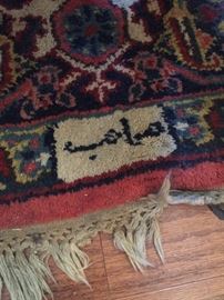 Signature woven into carpet. 