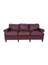  Pearson Sofa with Brass Nailhead Trim.  Upholstered in a chestnut colored leather with brass nailhead trim along the bottom apron and on the front of the rolled arms. Four wooden peg legs in the front and two larger on the backside of the sofa. The three attached back cushions are filled with 50% poly fiber, 35% waterfowl feathers and 15% polyurethane foam wrapped in 50% duck feathers and down, which help them keep their shape over time and do not sink down when sat upon. Pearson is a high-quality furniture source and no longer makes leather furniture so this item cannot be purchased new, however, was made originally to stand the test of time. A great, traditional piece and timeless look for an office, or den.
Dimensions: 88”l x 36”d x 33”h • Seat=20”h x 23”d (with pillows) • Arm=25”h
Condition: Leather has some nice, natural distressing and some minor scratches that can be rubbed out, particularly on the back side. 

