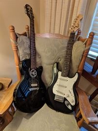 Two of several guitars. House on the hill