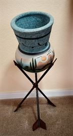 Pot sitting on arrow stand.