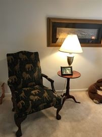 ANIMAL PRINT CHAIR WITH BEAUTIFUL CARVED  WOOD ARMS, LEGS AND CLAW FEET. ALSO A ROUND PEDESTAL TABLE AND TABLE LAMP