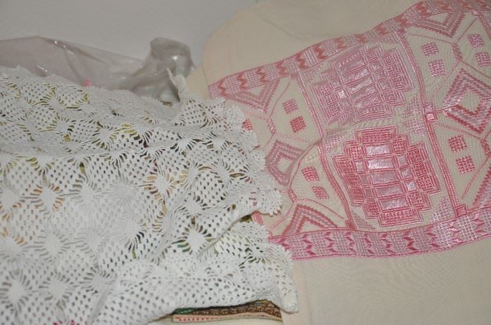 Large collection of hand-embroidered and crocheted table linens, including runners and table cloths