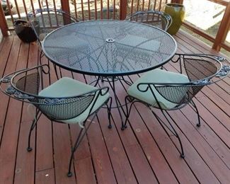 Wrought iron patio table & four chairs set with cushions.