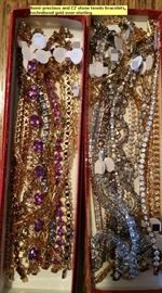 Dozens of gold over stelring or just sterling tennis bracelets with sparkling stones.