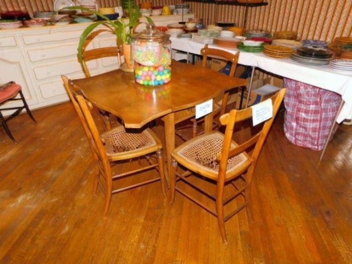 Small drop leaf table and four cane bottom chairs (as is)