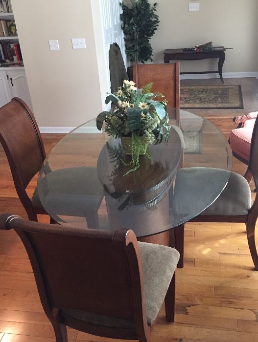 Dining room table with solid wood base and chairs (4) with upholstered seats; oval heavy glass top