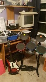 Guitar Hero Drums and Guitar, plus a Dinosaur Computer Monitor, assorted electronic, phone, and electrical cords
