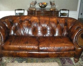 Family Room:  This is one of the two LEXINGTON Chesterfield-style leather sofas.  Notice the tufted tight back, two seat cushions, gently curved arms, and nail-head trim.  The sofa rests on wooden legs and measures 86" wide with a 35" tall back.  Each sofa is priced individually.  