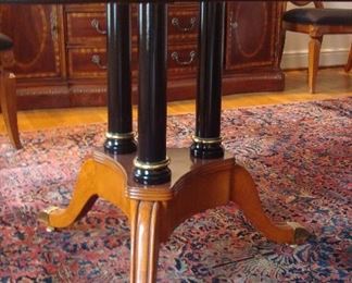 Dining Room:  This is one of the two brass footed pedestals supporting the dining table.  Notice that the black fluted columns match the black rim of the table skirt.  Carved medallions are at various sections of the table.  