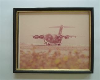 Collectibles-in Kitchen:  Framed photo (8-1/2" x 10-1/2") is a YC-15 airplane which won a competition
against Boeing's YC-14 and led to McDonnell Douglas winning the C-17 program which is now the backbone of the AIR MOBILITY COMMAND (AMC)
of the U.S. Air Force.  Today, AMC flies all military, humanitarian and VIP flights for the United States. 
That includes the secure transporting of the U.S. 
President's limousine, helicopter, tanks, etc. from
one site to another when the President travels. 
The President cannot use any other vehicles  supplied by another entity.
