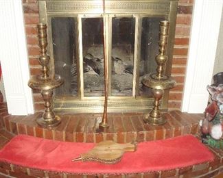 Family Room:  The hearth displays several items including a pair of 28-l/2" all brass cathedral candlesticks, a copper horn, a 21" tall concrete fox, and two bellows. 