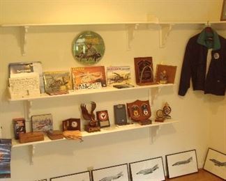 Bedroom #2-Upstairs:  This room is a treasure trove of various McDonnell-Douglas awards, books, VHS, DVDs and more!  The round clock hanging on the wall is a photo of an APACE AH-64 (McDonnell); below it are several related books on the APACHE.  In the corner is a jacket with a patch: GEMINI AIR CARGO.  The framed prints below are of the same  plane but for different branches of service (i.e., Navy, Marine, etc).  The dark blue McDonnell Douglas rug is also for sale.