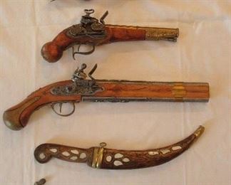 Collectibles in Kitchen:  The top pistol is real but "as is" (butt is missing).  It is a late 1700's SINGLE shot flintlock "boarding pistol." It was explained to me that perhaps the pirate would fire one shot at the intruder boarding the ship but then use the butt of the gun to hit the other intruders (that is probably how the butt got broken!). The other two guns and knives are decorative but would look great hanging on a wall!