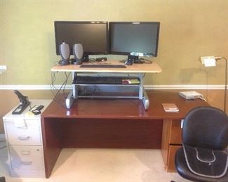 Bedroom #1-Upstairs:  A very popular "InMovement" standing desk rests on a "U" shaped desk.  The monitors; small Harmon/Kardon speakers; wireless mouse; hand rests; stapler; metal and wood-look file cabinets; armless office chair; router; and floor lamp are also for sale.