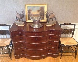Family Room:  Two HITCHCOCK chairs (priced individually) flank a four-drawer serpentine cherry chest.  The chest measures 48" wide x 23" deep x 35" tall.   Two signed elk figures are better shown in the next photo.  The silver-plate deer head bowl and tray are priced separately.  