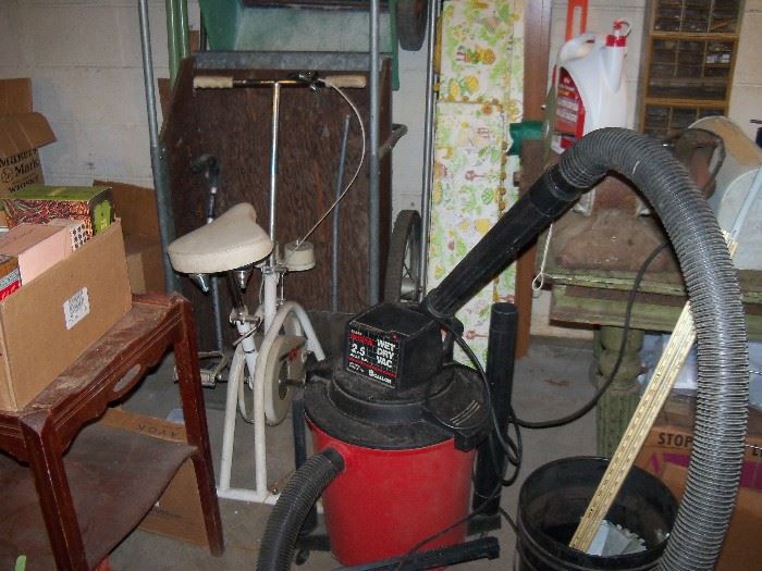 Shop vac, small table, exercise bike, garden card and seeder.