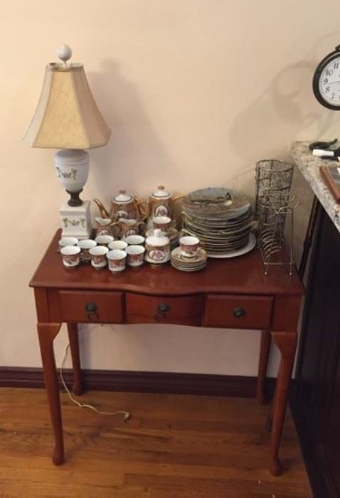 A side table with a collection of dishware on top.