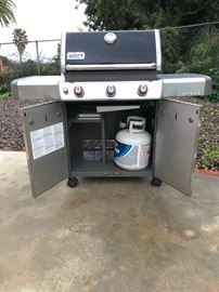 Weber Genesis gas grill on wheels with propane tank and racks included
