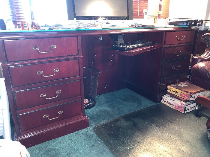 Two matching, mahogany colored office desks