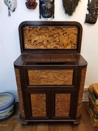 Antique Chinese, hand carved wood, Claw Foot Bar. This intricately carved two-tone dry bar features Asian figures, animals, flowers, and other scenes. The cabinet has a lift top and forward falling front panel that opens to a fitted interior with 8-bottle wine rack. Relief carved doors on the front, sides, and corners open for glassware storage. The glassware shown in the bar is INCLUDED. Glassware includes sets of wine glasses, snifter glasses, pilsner glasses, and more.  Be sure to look through all the pictures to see all the storage areas and the many ways this bar can open and close!  The bar when closed is 36" L X 18" W X 41" H. Please bring proper tools/dolly and help for removal.
***REMOVAL DAY FOR THIS ITEM IS THURSDAY, MARCH 14th FROM 10:00 A.M to 2:00 P.M ONLY. PLEASE BE SURE TO READ INFORMATION LOT "0" FOR SPECIAL REMOVAL INSTRUCTIONS ON THIS ITEM***