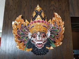 Authentic and colorfully ornate Balinese hand painted wood mask. Mask depicts the Barong from the traditional Balinese origin story. Dimensions are 19" W X 21" H.