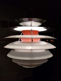 Vintage Scandinavian, mid-century modern, metal "PH Contrast" pendant light fixture by Poul Henningsen. This chandelier/hanging ceiling lamp was designed by Poul Henningsen and manufactured in Denmark by Louis Poulsen around the late 1950's/early 1960's. This is considered one of Henningsen's  best design pieces. This lamp has a white lacquered frame with aluminum plates  and colorful orange lacquer interior "contrast". The fixture is rated for 200 watts and has an E27 porcelain socket and a fabric cord. The fixture itself is approx 16"H at it's tallest point, and 16"W dia. at it's widest. It was purchased from International Design Center in the late 1960's. We found this piece online being resold for $2,500 - $4,000+. 
Please bring proper tools and equipment to removal in order to properly uninstall and cap off the electric.