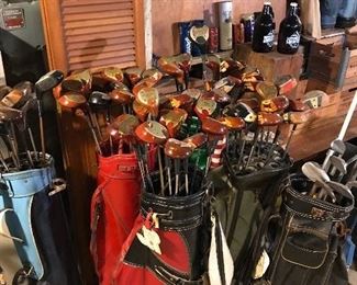Multiple vintage golf club woods and bags