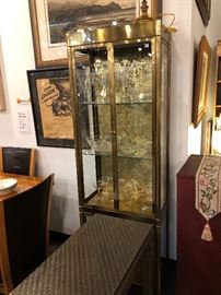 Brass Curio Cabinet lighted and filled to the brim with crystal great for that Easter dinner