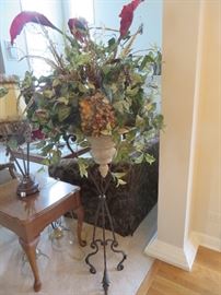 DECORATIVE URN WITH FLORAL ARRANGEMENT ON CAST IRON STAND

