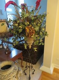 DECORATIVE URN WITH FLORAL ARRANGEMENT ON CAST IRON STAND
