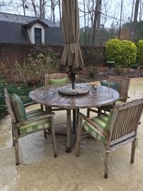 Teak patio furniture.  Table with lazy susan, umbrella and four chairs.  Two additional chairs & side table also available.  