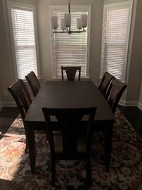 Dining room table with leaf and 8 chairs like new; approximately one year old