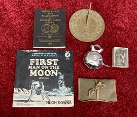 1976 coin black book, brass sundial, commemorative record of moon landing, vintage bicycle bell, peweter figurines, and vintage military sewing kit