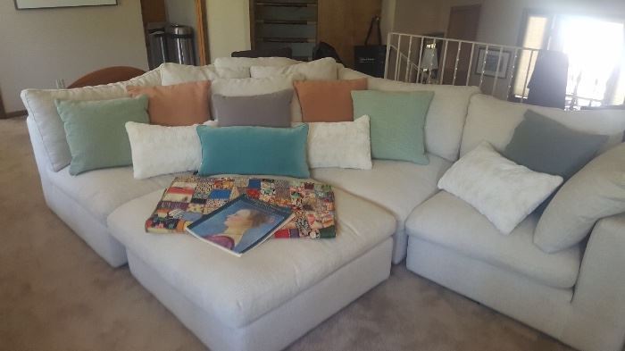 Comfortable neutral colored sectional and a variety of beautiful throw pillows