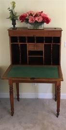This early 1900's Southern Plantation Desk  with Country Sheraton turned feet,  original casters was designed to replace from home to horse drawn wagon and taken onto the plantation fields to do work by the owner or the overseer.  These beautiful light weight desks were also used by Aides-De-Camps to write letters and complete documents for their commanding Confederate officers in the field. Very nice find.