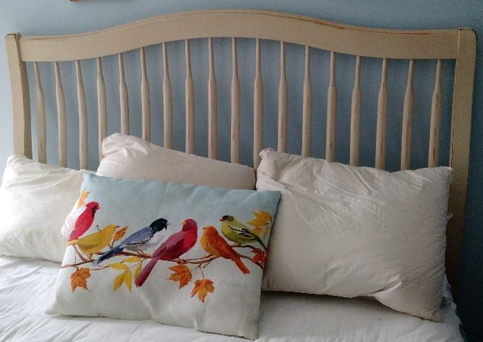 Close Up View of Headboard on a full size bed featuring a beautiful hand painted pillow