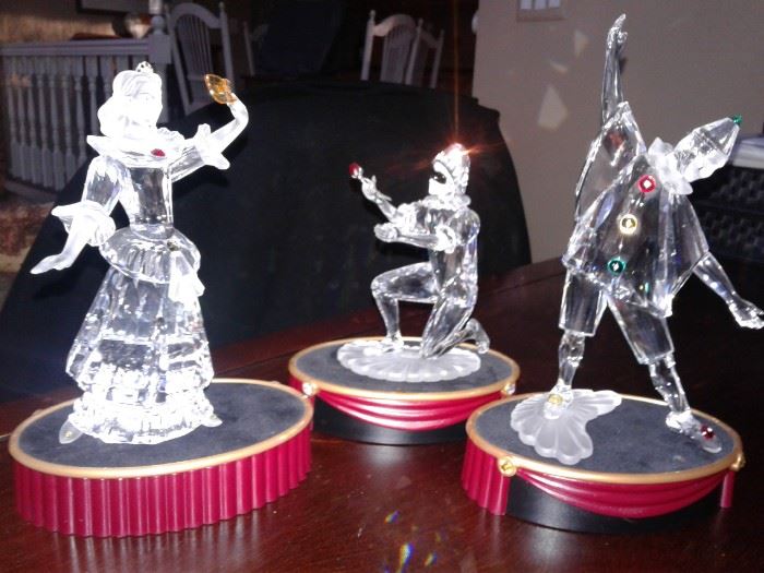 Swarovski Crystal Limited Edition "masquerade harlequin".  The fellow on his knee was the 2001 issue.  The other 2 harlequin were offered in 2002 and 2003. 
