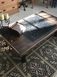 Interesting coffee table made from old plank (flooring?) with cast iron grate inset.  Piece of glass over the top. Cool!