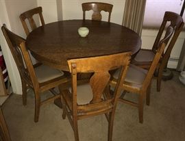Round oak table with 4 leaves and 6 oak chairs (excellent condition)