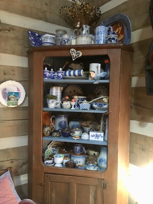 Corner cupboard filled with blue and white pottery & dishes 
