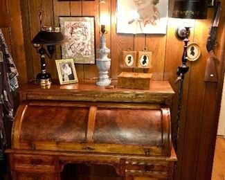 Fromt view with cylinder closed of an antique walnut cylinder top desk with figured walnut accents. 