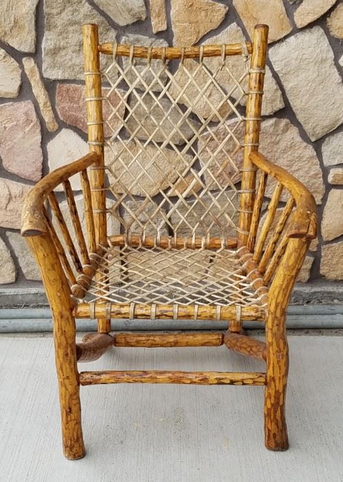 Peeled log and snowshoe weave rawhide chair from the historic Leeks Lodge in Jackson, Wyoming.