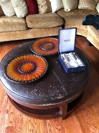 Very distress leather ottoman. Silver plated champagne flutes. Curious orange beveled platter type things -- you need this!